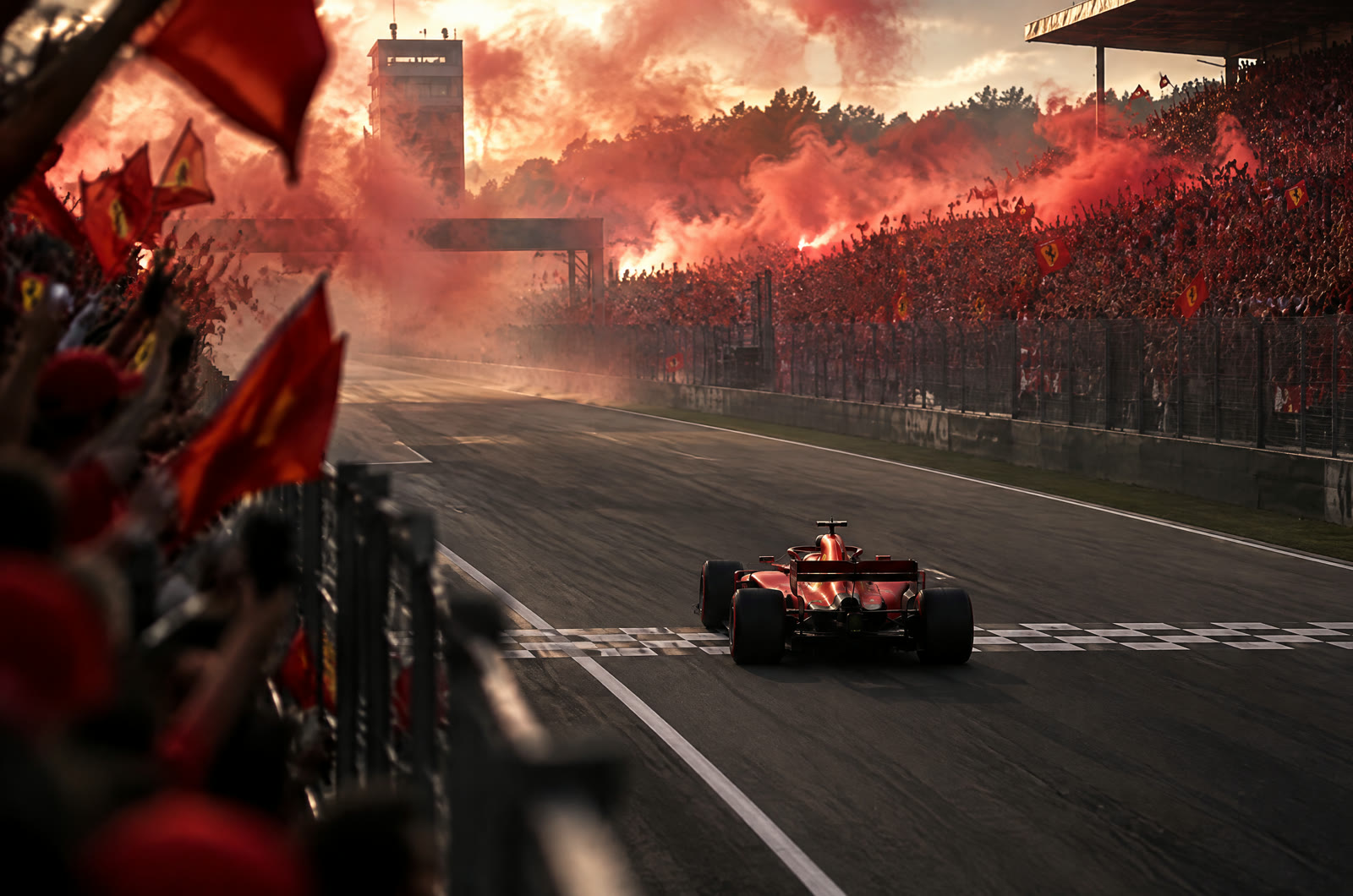 A red Ferrari crossing the line at Monza in front of the tifosi